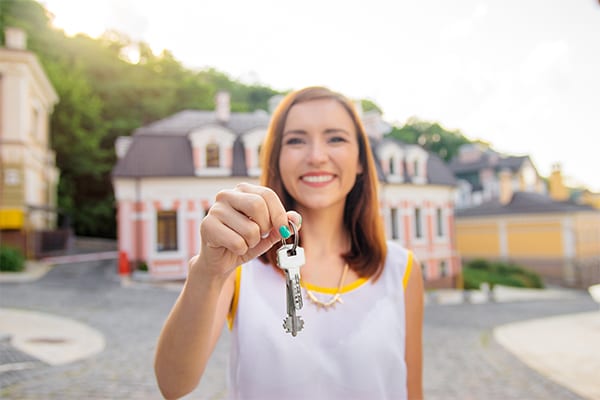 A smiling woman holding a set of keys