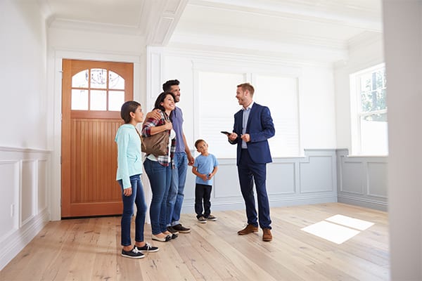 A family looking at a house with a realtor